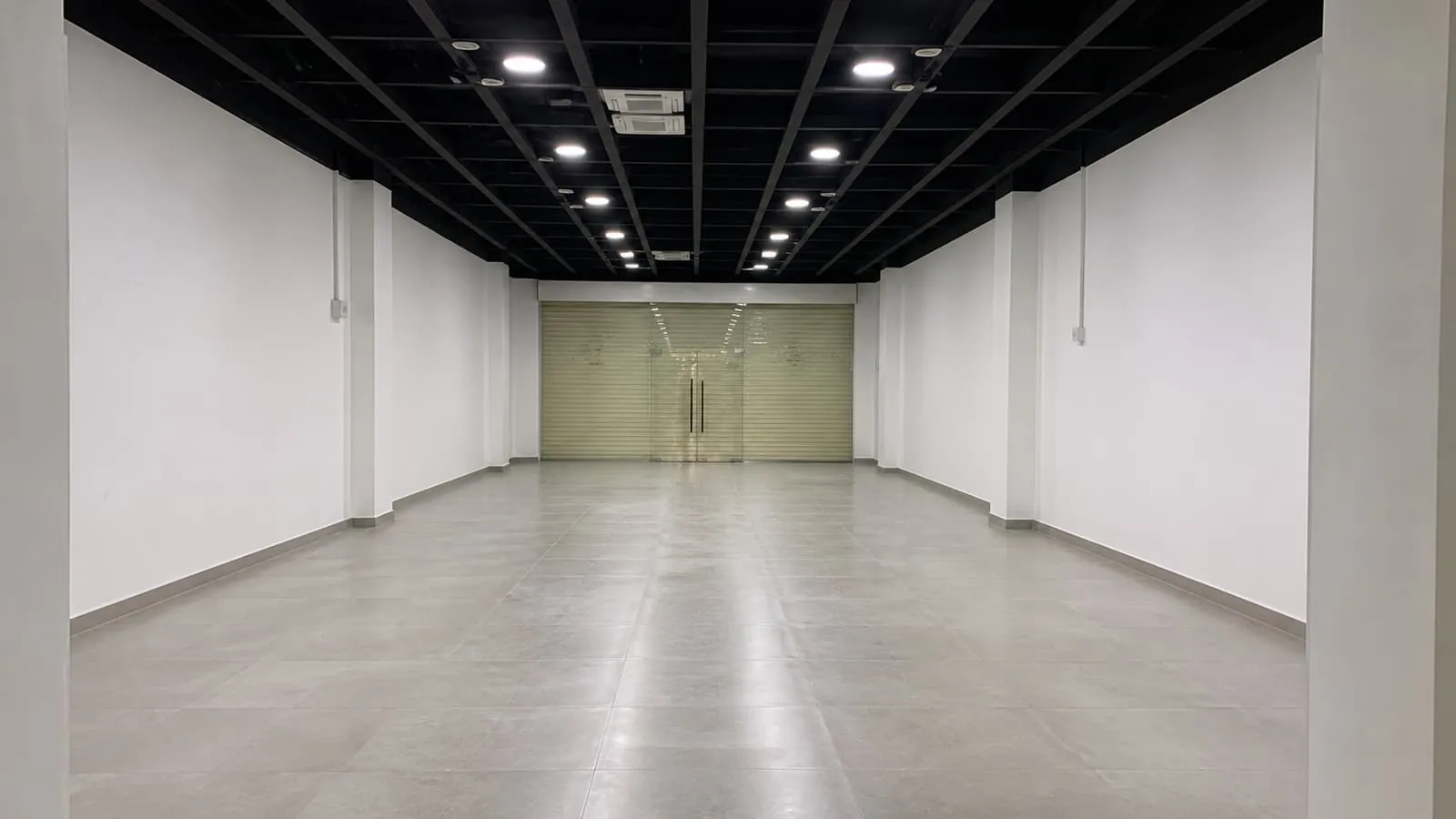 A cleaned, empty retail lot with lighting on, ready for handback.