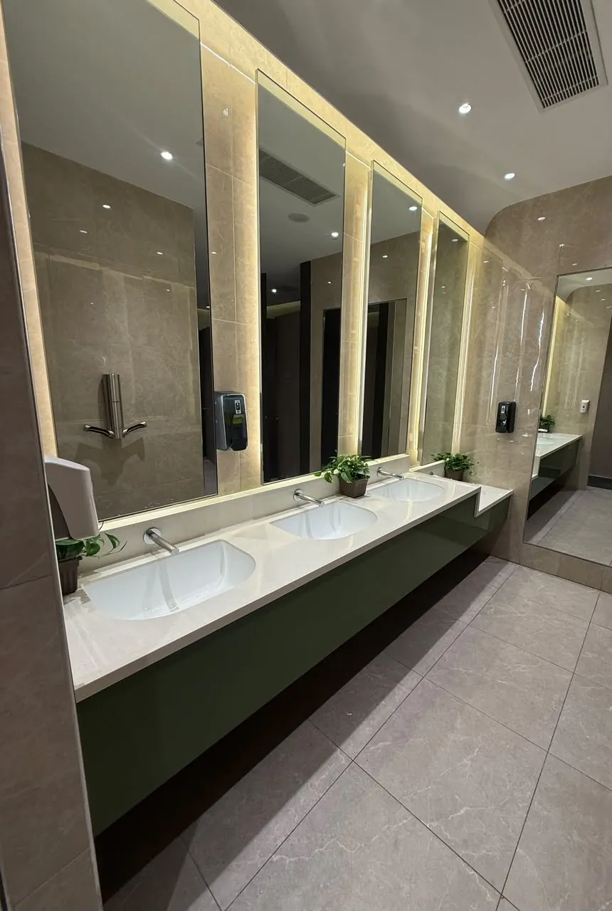 Completed vanity counter with backlit mirrors and stone finishes in the upgraded mall toilet.