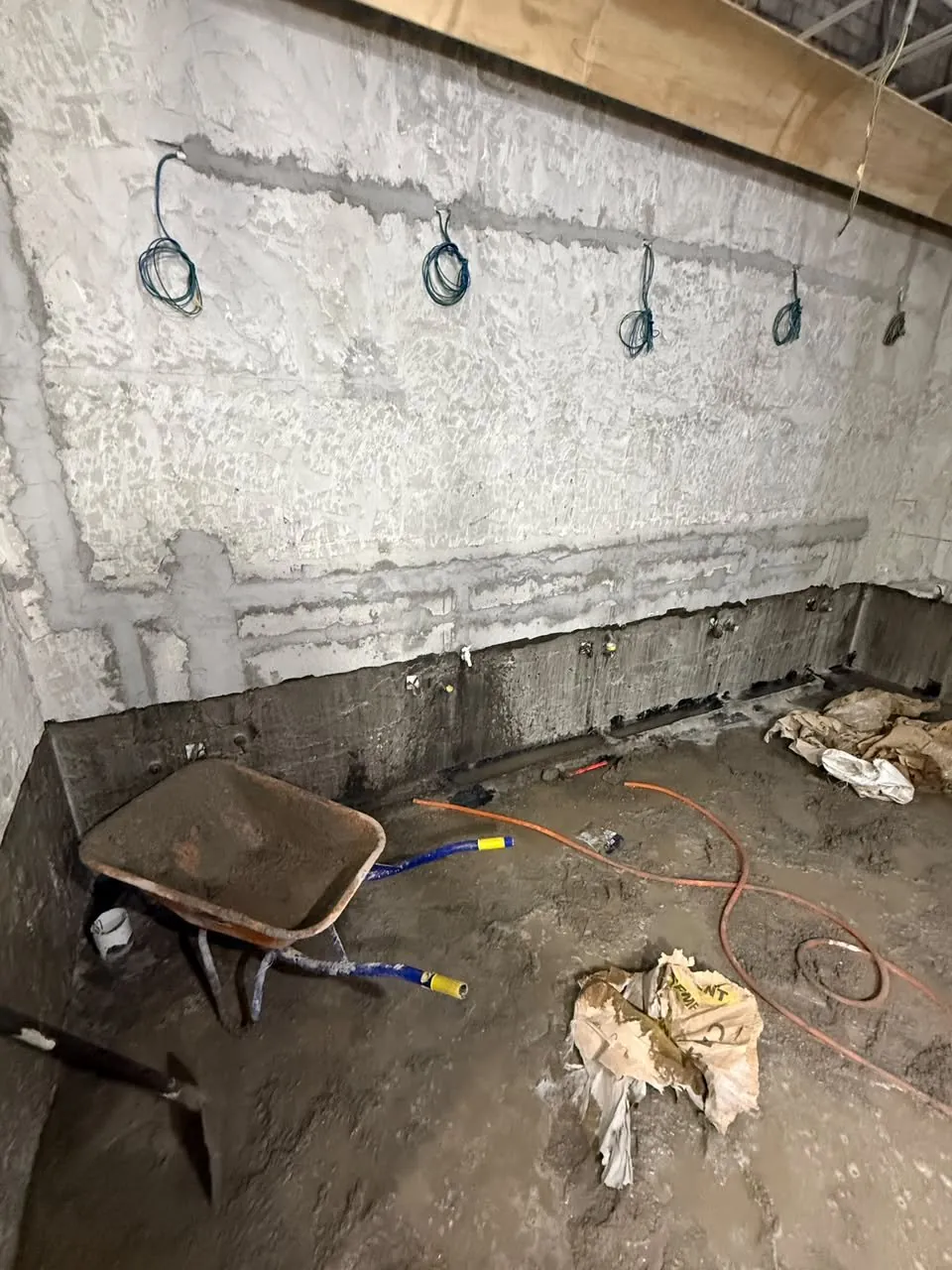 Sanitary services set out on bare walls during the toilet upgrade, floor screed in progress.